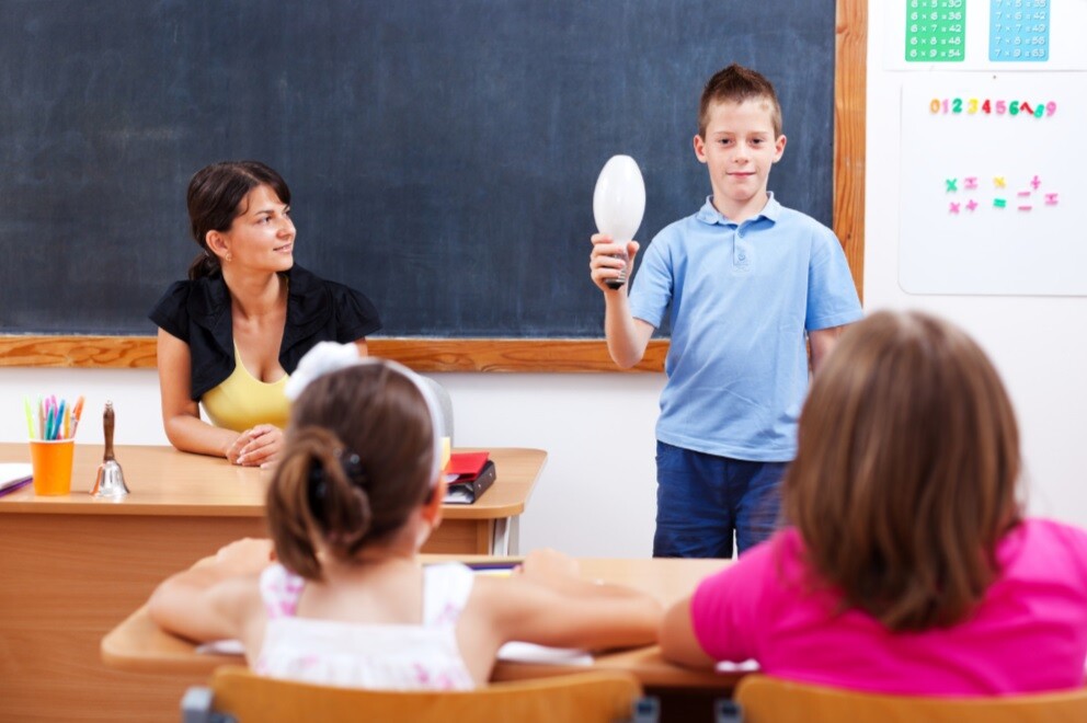 child holding up a light bulb for show and tell