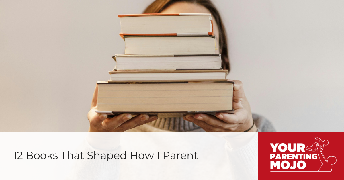 Person holding a tall stack of books in front of their face